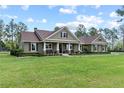 Inviting single story home featuring an expansive lawn, rocking chair front porch, and neutral exterior at 23247 Lake Seneca Rd, Eustis, FL 32736