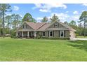 Inviting single story home featuring an expansive lawn, rocking chair front porch, and neutral exterior at 23247 Lake Seneca Rd, Eustis, FL 32736