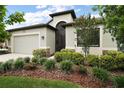 Beautifully landscaped front yard with lush greenery and a modern home exterior at 2400 Pawtucket Pass, Mount Dora, FL 32757