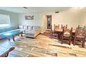 Open-concept living room showcasing a cozy sofa, decorative chairs, and stylish wood-look flooring at 2433 Adams Ave, Deltona, FL 32738