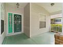 Up close view of the front porch and glass adorned green front door at 25025 Cranes Roost Cir, Leesburg, FL 34748