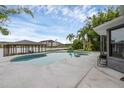 Backyard oasis features a modern pool and spa, complemented by a covered dock and serene lake views at 2610 Florence Dr, Kissimmee, FL 34744
