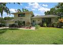 Charming two-story home with a well-manicured lawn, mature trees and a brick facade at 27212 Orange Ave, Yalaha, FL 34797