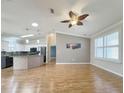 Open-concept living room showcases hardwood floors and seamless flow into the modern kitchen at 3237 Atwell Ave, The Villages, FL 32162