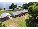 Waterfront home featuring an outdoor carport, and manicured landscaping at 38314 Echols Rd, Leesburg, FL 34788