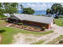 Beautiful lakefront home featuring a brick exterior and well-manicured front yard landscaping at 38314 Echols Rd, Leesburg, FL 34788