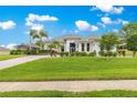 Attractive one story home with a long brick paved drive leading to a welcoming facade with meticulous landscaping at 39145 Treeline Dr, Lady Lake, FL 32159