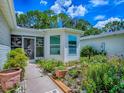 Close-up shot of a well-maintained walkway to a lovely screened in porch surrounded by beautiful landscaping at 409 Westwood Dr, Leesburg, FL 34748