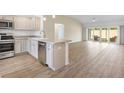 Open kitchen with stainless steel appliances, granite countertops, and an island that flows into the living area at 4157 Tiedemann Loop, The Villages, FL 32163