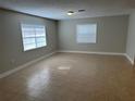 A bright and airy living room with tile floors and two large windows at 460 Wisteria Ave, Umatilla, FL 32784