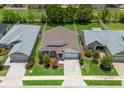 Aerial view of a well-maintained single Gathering home with manicured lawns, mature trees, and gray roof at 5019 Ne 125Th Loop, Oxford, FL 34484