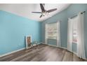 Stylish bedroom with wood-look floors, a modern fan, and ample natural light from the windows at 5068 Ne 121St Ave, Oxford, FL 34484