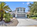 Charming two-story home with a well-manicured lawn, long driveway, and lovely landscaping at 5964 Brittania Blvd, Tavares, FL 32778