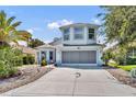 Charming two-story home with a well-manicured lawn, long driveway, and lovely landscaping at 5964 Brittania Blvd, Tavares, FL 32778