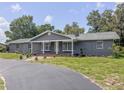 View of the gray-colored single story home featuring a well-manicured lawn and inviting front entrance at 604 Ponderosa Dr, St Cloud, FL 34769