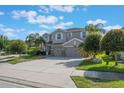 Attractive two-story home with a three-car garage, lush landscaping, and a spacious driveway at 637 Neptune Dr, Groveland, FL 34736