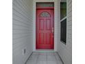 Inviting red front door with sidelight and transom window at 712 Old Oaks Ln, Leesburg, FL 34748