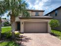 Charming two-story home with a brick driveway and a two car garage at 8800 Corcovado Dr, Kissimmee, FL 34747