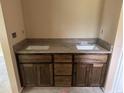 Bathroom vanity with double sinks, dark wood cabinets, and granite countertop, offering plenty of space and style at 891 Cr 482C, Lake Panasoffkee, FL 33538