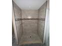 Modern walk-in shower featuring neutral tile, decorative accents, and built-in shelving for a spa-like experience at 891 Cr 482C, Lake Panasoffkee, FL 33538