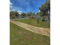 View of home with grassy front yard and sidewalk, accented by mature trees and flowering bushes at 100 W Idlewild Ave, Eustis, FL 32726