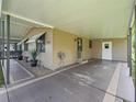 Covered carport area with painted concrete floor and exterior storage closet, providing ample covered parking at 1005 Richard Dr, The Villages, FL 32159