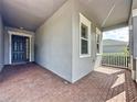 Covered front porch featuring brick flooring and a welcoming entrance at 101 Flame Vine Way, Groveland, FL 34736