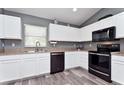 Modern kitchen with sleek white cabinets, stainless steel appliances, and durable laminate flooring at 1132 Hill Mount Dr, Minneola, FL 34715