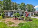 Inviting single-story home featuring a lush front yard with mature trees and vibrant landscaping in a tranquil neighborhood at 1156 Capella Dr, Tavares, FL 32778