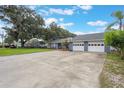 Long driveway with a basketball hoop leads to the attached garage, offering ample parking and recreational space at 11750 Watts Ct, Tavares, FL 32778