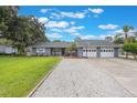 A well-maintained home exterior showcases a three-car garage, landscaped front yard, and charming curb appeal at 11750 Watts Ct, Tavares, FL 32778