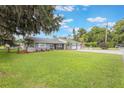Spacious front yard features lush green grass, mature trees, and a well-maintained exterior, enhancing curb appeal at 11750 Watts Ct, Tavares, FL 32778