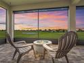 Screened-in outdoor patio with firepit and comfortable seating overlooking the golf course at 12198 Se 176Th Loop, Summerfield, FL 34491