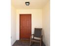 Cozy entryway featuring a brick floor, a wooden rocking chair, and a painted front door at 1325 Balboa Ct, The Villages, FL 32159