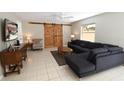 Comfortable living room with a large sectional couch, sliding barn doors, and a flat screen television at 1325 Balboa Ct, The Villages, FL 32159