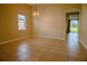 Bright dining room boasts neutral paint, tile flooring, and natural light, offering a versatile living space at 1355 Misty Glen Ln, Clermont, FL 34711