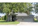 Inviting single-story home showcases a well-maintained lawn, lush landscaping, and a convenient three-car garage at 1355 Misty Glen Ln, Clermont, FL 34711