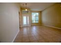 Spacious living room features neutral paint, tile flooring, and large windows that fill the space with natural light at 1355 Misty Glen Ln, Clermont, FL 34711