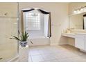 Bathroom featuring a walk-in shower, a separate soaking tub, and a vanity area at 1426 Lakemist Ln, Clermont, FL 34711