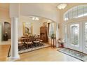 Grand foyer boasts high ceilings, a decorative glass front door, and views of the formal dining area at 1426 Lakemist Ln, Clermont, FL 34711