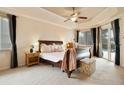 Comfortable main bedroom featuring tray ceilings, a ceiling fan, and access to the pool area at 1426 Lakemist Ln, Clermont, FL 34711