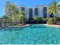 Beautiful resort-style pool with lounge chairs surrounded by lush tropical landscaping near the condos at 14501 Grove Resort Ave # 3406, Winter Garden, FL 34787