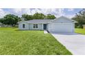 Inviting single-story home with a well-manicured lawn and an attached two-car garage at 14611 Se 95Th Ct, Summerfield, FL 34491