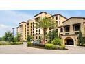 Exterior view of the resort with a palm tree in the circle drive and the building entrance at 16300 County Road 455 # 202, Montverde, FL 34756