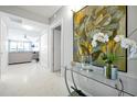 Bright condo foyer with white tile flooring, console table, and an open view to the living room at 16300 County Road 455 # 202, Montverde, FL 34756
