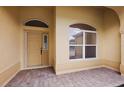 Inviting front porch with brick flooring, a front door, and an arched window at 16862 Se 80Th Bellavista Cir, The Villages, FL 32162