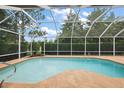 Screened-in pool and patio area surrounded by lush greenery, providing a private outdoor retreat at 16862 Se 80Th Bellavista Cir, The Villages, FL 32162