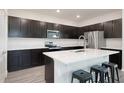 Bright kitchen featuring dark cabinets, stainless steel appliances, quartz countertops, an island, and a modern sink at 1696 Wilson Prairie Cir, Groveland, FL 34736