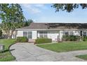 Inviting single-story home with manicured lawn, and covered entrance at 1726 Tropical Ct, Tavares, FL 32778
