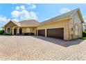 Attractive home with a three-car garage, brick paver driveway, and a charming stone facade at 18008 Victorian Dr, Clermont, FL 34715